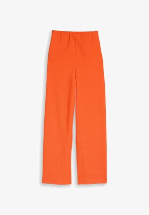 Pantaloni larghi arancioni vivaci con texture e vita elastica, mostrati distesi su sfondo bianco.
