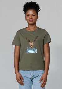 Olijfgroene T-shirt met korte mouwen, voorzien van een gedetailleerde afbeelding van een hertenkop die een blauw-wit gestreept shirt draagt.