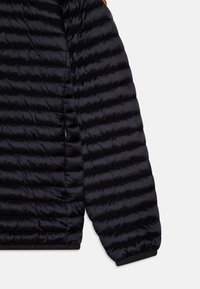Giacca a vento nera con design trapuntato, caratterizzata da una texture liscia e lucida e polsini elasticizzati. Include dettagli con tasche laterali con zip.