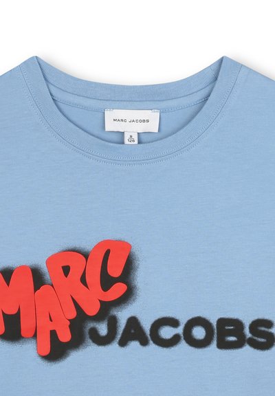T-shirt di cotone azzurro chiaro con scritte rosse in grassetto "MARC" e "JACOBS" nere, colletto rotondo e maniche corte.