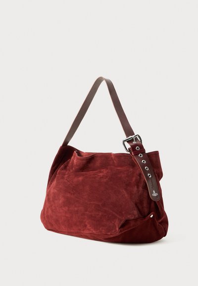 Sac à épaule en suede rouge foncé doux avec une large sangle réglable en cuir marron, ornée d'œillets en métal et d'une boucle.