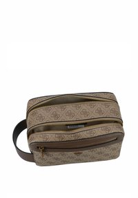 Bruine crossbody tas met een patroon, voorzien van meerdere zippered compartimenten en een bruine schouderband, met gouden hardware en logo accenten.