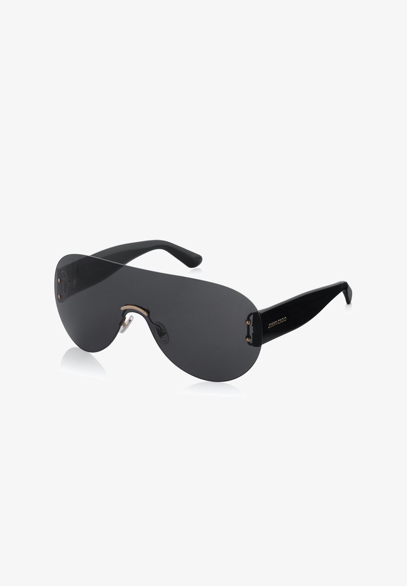 Lunettes de soleil avec des verres noirs surdimensionnés, monture en plastique noir élégant, accents dorés et un design de pont unique. Texture lisse sur l'ensemble.