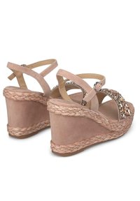 Sandali con zeppa dal superiore in suede rosa, piattaforma in juta intrecciata e decorazioni con strass sul cinturino. Cinturini alla caviglia regolabili.