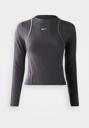 Langarm sporttop in donkergrijs, gemaakt van rekbaar materiaal, met een ronde halslijn en contrasterende stiksels. Nike-logo op de borst.