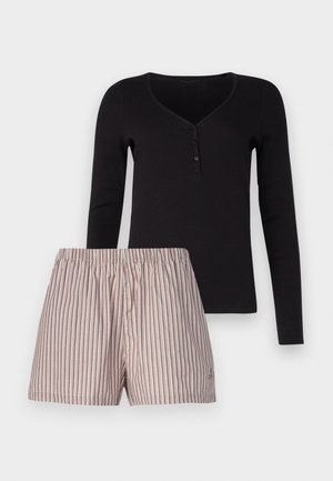 Haut noir à manches longues avec patte de boutonnage, assorti à un short rayé de couleur claire avec une taille élastique. Matière en coton.