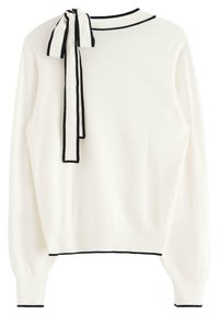 Pull blanc en tissu doux et texturé, avec un bord noir le long de l'encolure et des poignets, agrémenté d'un détail de nœud noir au col.
