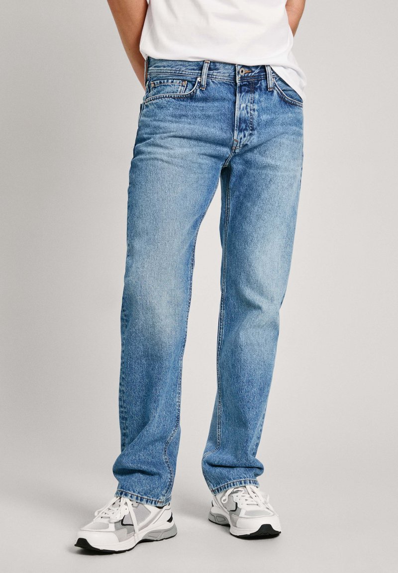 Světle modré džíny z denimu s rovným střihem nohavic, pětipokláčovým designem a viditelným prošitím. Vhodné kombinované s bílými a šedými sportovními teniskami.