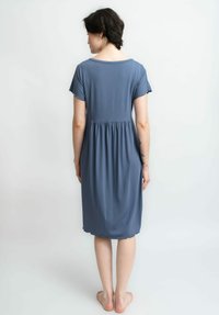 Blaues knielanges Kleid aus weichem Stoff, mit kurzen Ärmeln, einer gerafften Taille und einem runden Ausschnitt mit gewelltem Rand.