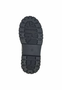 Suela de zapato de goma negra con profundas estrías antideslizantes y surcos horizontales. Presenta un logotipo circular en la zona del talón.