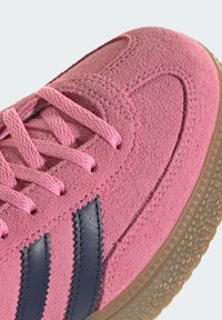 Rosa sneakers i mocka med strukturerad yta, med mörkblå läderremsor och rosa snören. Gummisula med mönstrat grepp.