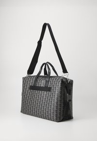 Black and gray patterned bag with a rectangular shape, featuring two top handles and a detachable shoulder strap. Textured material with accents.
