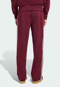 Μαρούλι αθλητικά παντελόνια με λευκές πλαϊνές ρίγες, κατασκευασμένα από λείο ύφασμα, με ελαστική μέση και ίσια γραμμή σχεδίασης.