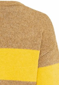 Strikket sweater i brun med brede gule striber. Har en rund halsudskæring og et struktureret stof med en glat overflade.