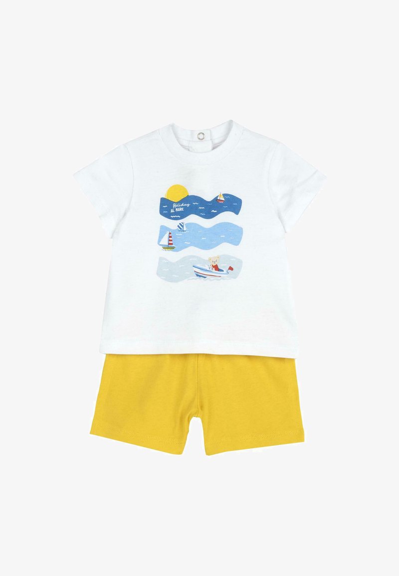 T-shirt blanche avec un motif représentant un soleil, des bateaux et des vagues ; associé à un short jaune. Tissu en coton, à manches courtes et coupe décontractée.