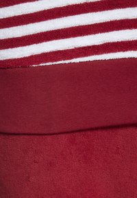 Červené oblečenie s textúrovanou hornou časťou a bielymi pruhmi, hladkou jednofarebnou červenou dolnou časťou. Mäkká tkanina po celom obvode.