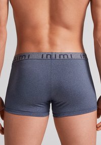 Námořnické modré boxerky s hladkým povrchem, elastickým pasem a nenápadným logem značky. Mají těsný střih a krátkou délku nohavic.