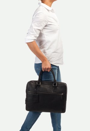 Bolsa de cuero negro para portátil con asas dobles, un bolsillo con cremallera en el frente y una etiqueta de equipaje. Textura suave con un acabado rugoso. Forma rectangular.