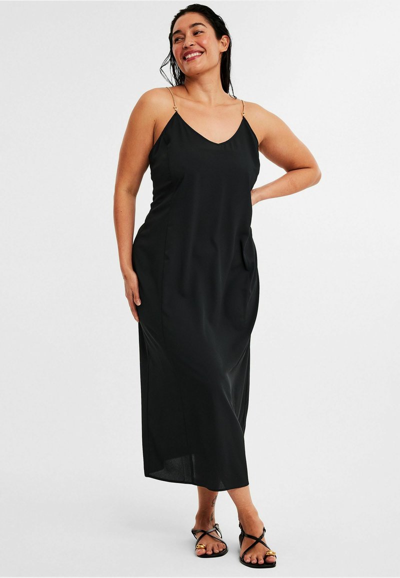 Schwarzes Maxikleid aus glattem Stoff, mit dünnen Trägern mit metallischen Akzenten, einem V-Ausschnitt und einem lockeren Schnitt mit Seitentaschen.