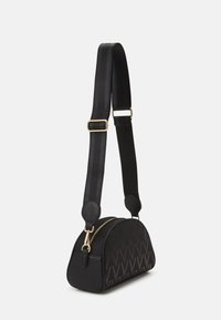 Sac à main noir en forme arrondie, en matériau texturé, avec des fermetures éclair dorées et une bandoulière rayée réglable. Présente un motif de logo sur le corps.