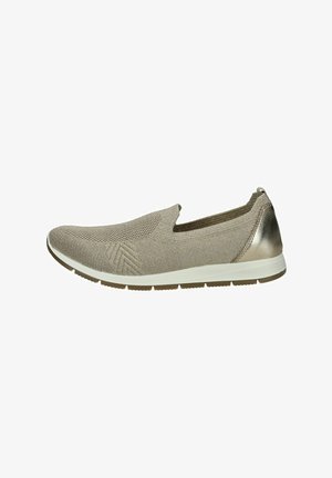 Zapato tipo slip-on en material de punto beige con un acabado texturizado. Presenta un acento metálico en el talón y una suela de goma blanca para mayor tracción.