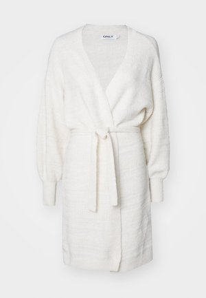 Cardigan blanc texturé avec un design enroulé, des manches bouffantes longues et une ceinture à nouer. Présente des poignets côtelés et un tissu subtilement imprimé.