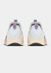 Αθλητικά παπούτσια με ανοιχτό γκρι επάνω μέρος, μωβ λεπτομέρειες και ανοιχτό μπεζ σόλα. Διαθέτουν υφασμάτινο σχέδιο και έντονο τακούνι.