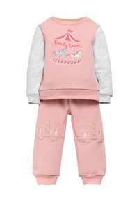 Sudadera rosa con mangas grises que presenta un gráfico de carrusel, combinada con pantalones rosas adornados con acentos de cuerno de unicornio en beige.