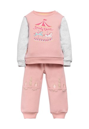 Sudadera rosa con mangas grises que presenta un gráfico de carrusel, combinada con pantalones rosas adornados con acentos de cuerno de unicornio en beige.