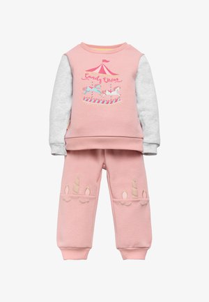 Sudadera rosa con mangas grises que presenta un gráfico de carrusel, combinada con pantalones rosas adornados con acentos de cuerno de unicornio en beige.