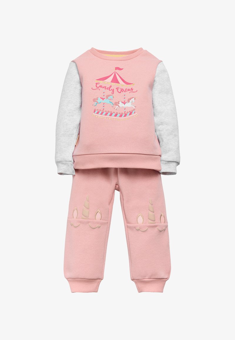 Sudadera rosa con mangas grises que presenta un gráfico de carrusel, combinada con pantalones rosas adornados con acentos de cuerno de unicornio en beige.
