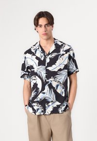 Camicia a maniche corte con bottoni in tessuto nero, caratterizzata da un motivo tropicale di foglie bianche e azzurro chiaro, con una vestibilità comoda e design con colletto.