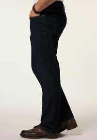 Tumman siniset farkut, joissa on suora lahje, viisi taskua, hienovaraisia ommeltuja yksityiskohtia ja keskipitkä vyötärö.