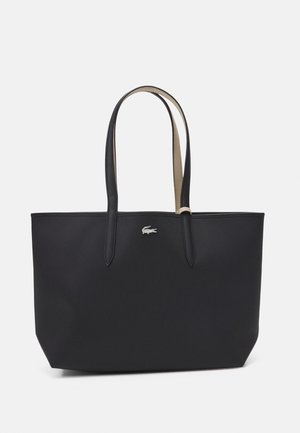 Zwarte totebag met een gestructureerde vorm, gemaakt van textuurmateriaal, met twee lange handvatten en een klein zilveren logo aan de voorkant.