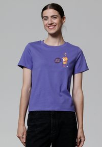 T-shirt en coton violet avec des manches courtes et un graphique d'un chat dans une tasse avec le texte « Houston, nous avons un problème. »