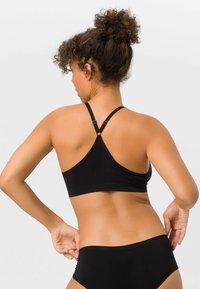 Schwarzer Sport-BH mit Racerback-Design, aus glattem Material gefertigt. Verfügt über verstellbare Träger und eine minimalistische Silhouette.