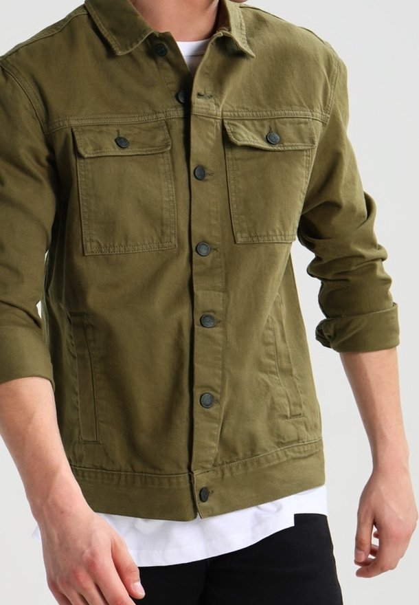 Veste en denim vert olive avec fermeture à boutons, deux poches poitrine et un ourlet droit. Le tissu est légèrement texturé.