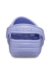 Crocs violets avec une surface texturée, une sangle de talon ajustable et plusieurs trous de drainage pour la ventilation. Matériau en caoutchouc moulé.