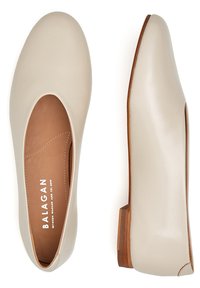 Ballerine in pelle beige con punta rotonda, design minimalista e tacco in legno piccolo. All'interno presentano cuciture visibili e logo.