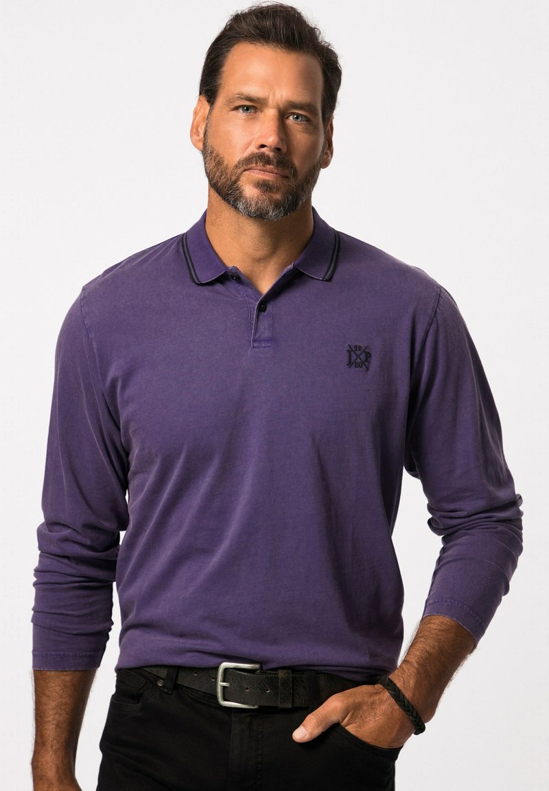 Paars polo shirt met lange mouwen en een zwarte kraagdetail en klein logo. Draagt met zwarte broek en een gestructureerde zwarte riem.
