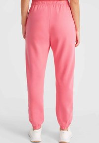 Rosa joggers med elastisk midja och rynkade muddar. Tillverkade i mjukt material har de sidofickor och en avslappnad passform för komfort.