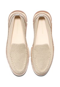 Beiga slip-on-skor med texturerad stickad ovandel, kontrasterande sömmar och en tan gummisul. Minimalistisk design med rund tå.