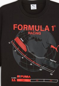 Sort t-shirt med et globus design og rød "FORMULA 1 RACING" tekst, en bane grafik der angiver bremse- og accelerationzoner, samt "TURN 11."