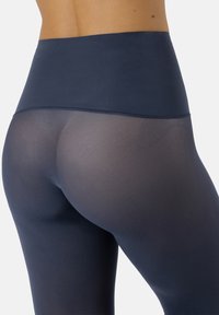 Leggings a vita alta di colore blu navy, realizzati in un tessuto elastico e semitrasparente. Presentano una cintura liscia e modelli testurizzati lungo la gamba.
