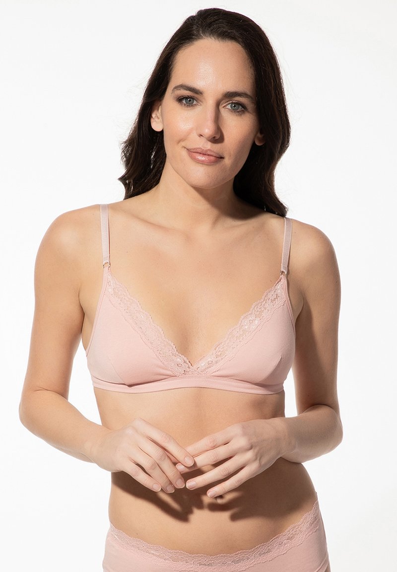Light pink bralette with lace trim, v-neck design, adjustable straps, soft fabric, and no underwire for comfort. Features a seamless look.