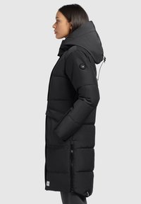 Black puffer coat with a hood, featuring a zippered side pocket, stitched design, and a logo patch on the upper sleeve.