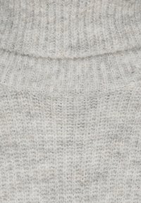 Close-up of light grey ribbed knit fabric with visible soft, fuzzy texture and subtle vertical stripe pattern.