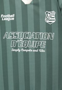 Grønstribet fodboldtrøje med hvid krave. Har teksten "Football League" og "ASSOCIATION D'ÉQUIPE" i fed hvid skrifttype.