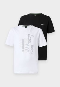 Twee T-shirts met korte mouwen: één wit met grafisch ontwerp en logo, één effen zwart met logo. Katoenen materiaal, ronde halsstijl.