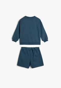 Blå bomuldsjersey-outfit bestående af en langærmet sweatshirt og matchende shorts, med ribbet halsudskæring og talje for komfort.